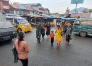 Babinsa Koramil 03/Berastagi Berikan Pelayanan Prima Dengan Bantu Seberangkan Anak Sekolah dan Masyarakat