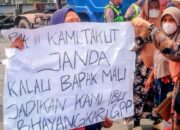 Warga Bagan Deli membawa poster protes saat unjuk rasa di Polres Pelabuhan Belawan